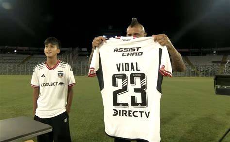 Arturo Vidal firmando camiseta a niños