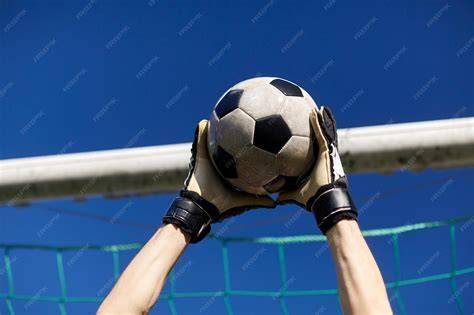 Manos de arquera atrapando pelota