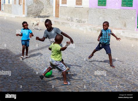 Niños jugando fútbol en barrio
