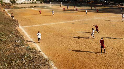 Jugadores de fútbol en cancha de tierra