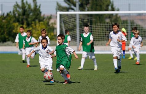 niños jugando fútbol en cancha sintética