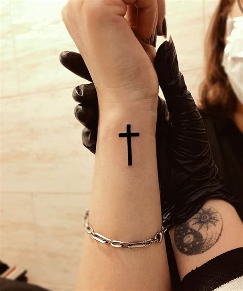 cruz Anj tatuaje en muñeca