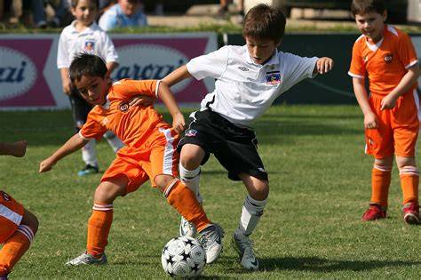 Niños jugando fútbol infantil en Chile