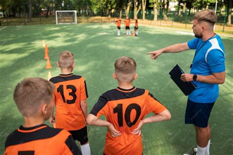 Entrenador enseñando placaje seguro a niños