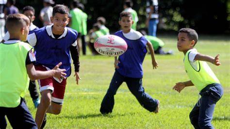 Rugby escolar comunitario niños jugando en equipo