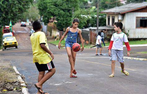 Niños jugando fútbol en una calle brasileña