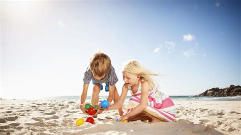 Niños jugando vóley playa en la arena