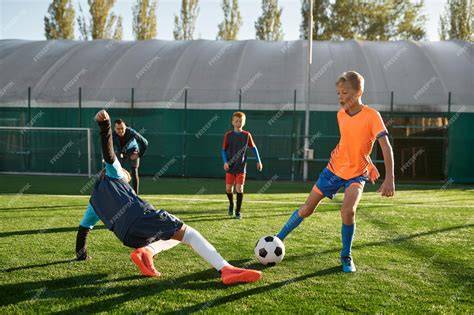 niños jugando fútbol en escuela deportiva