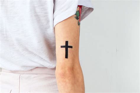 tatuaje de cruz con listón rojo